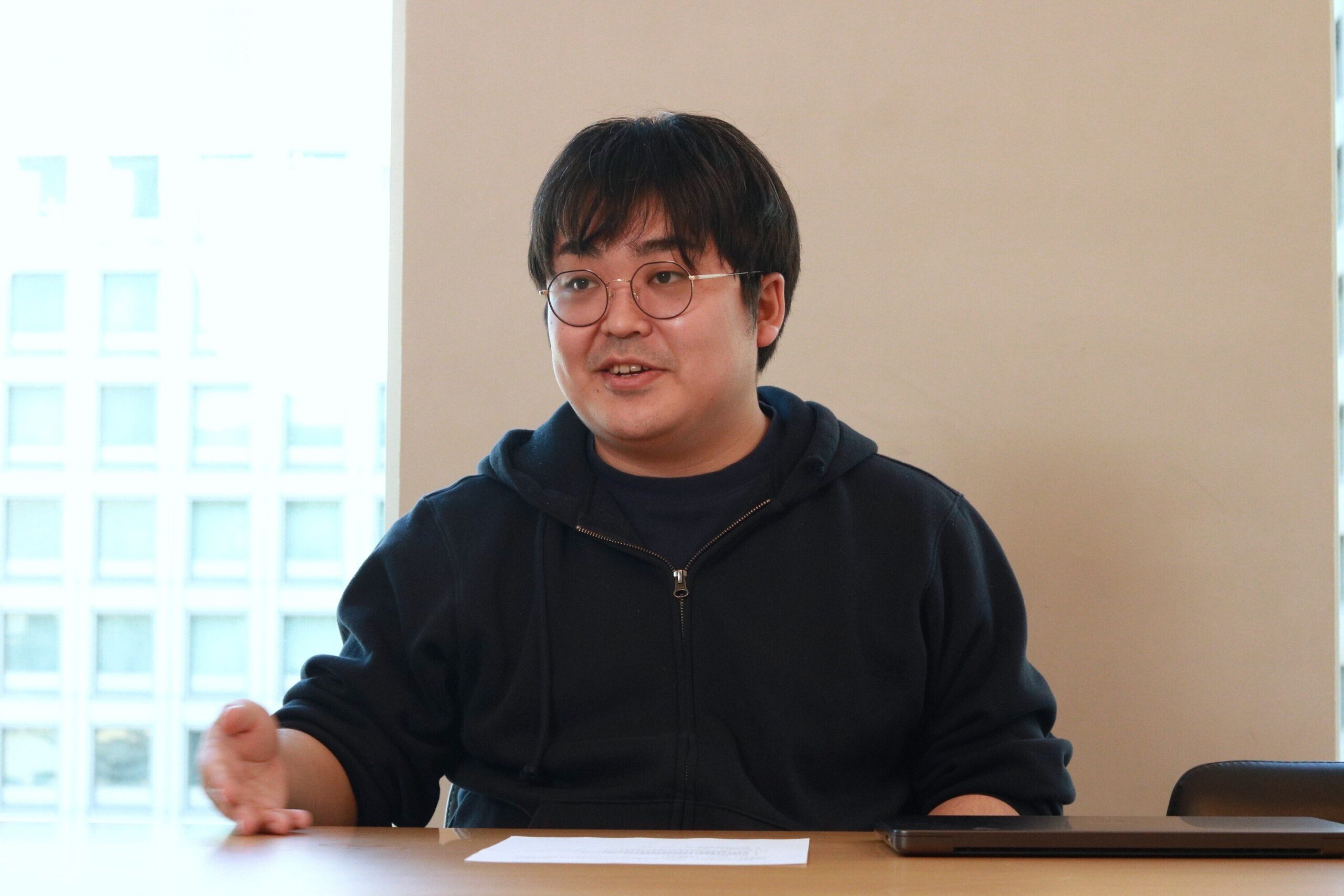 オフィスの窓を背にインタビューに答えるAlumnoteのご担当者