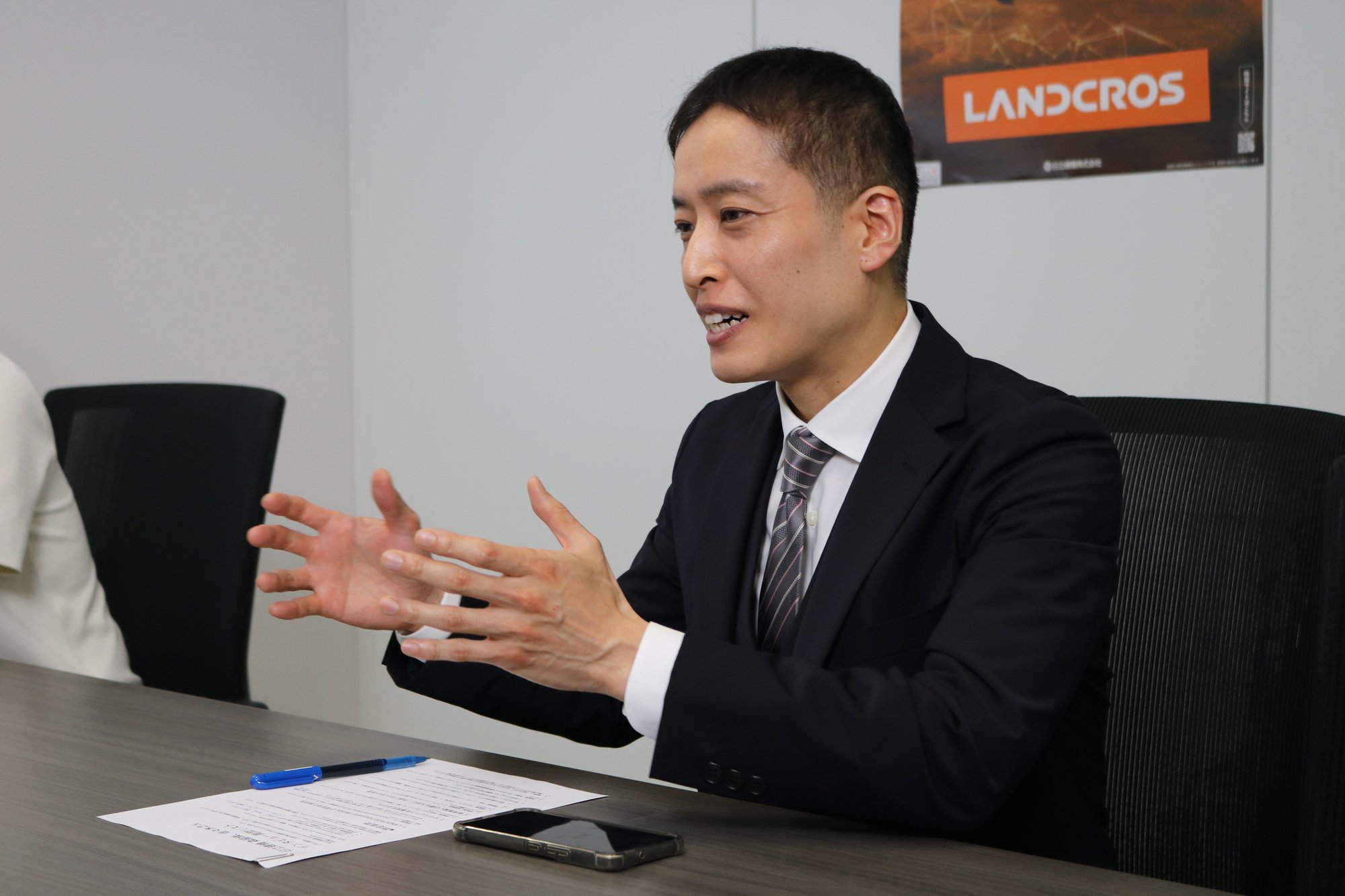 事業部に刺さる提案の組み立て方について語る、ハイタレント経由で参画する佐々木さん。背景にLANDCROSのロゴ