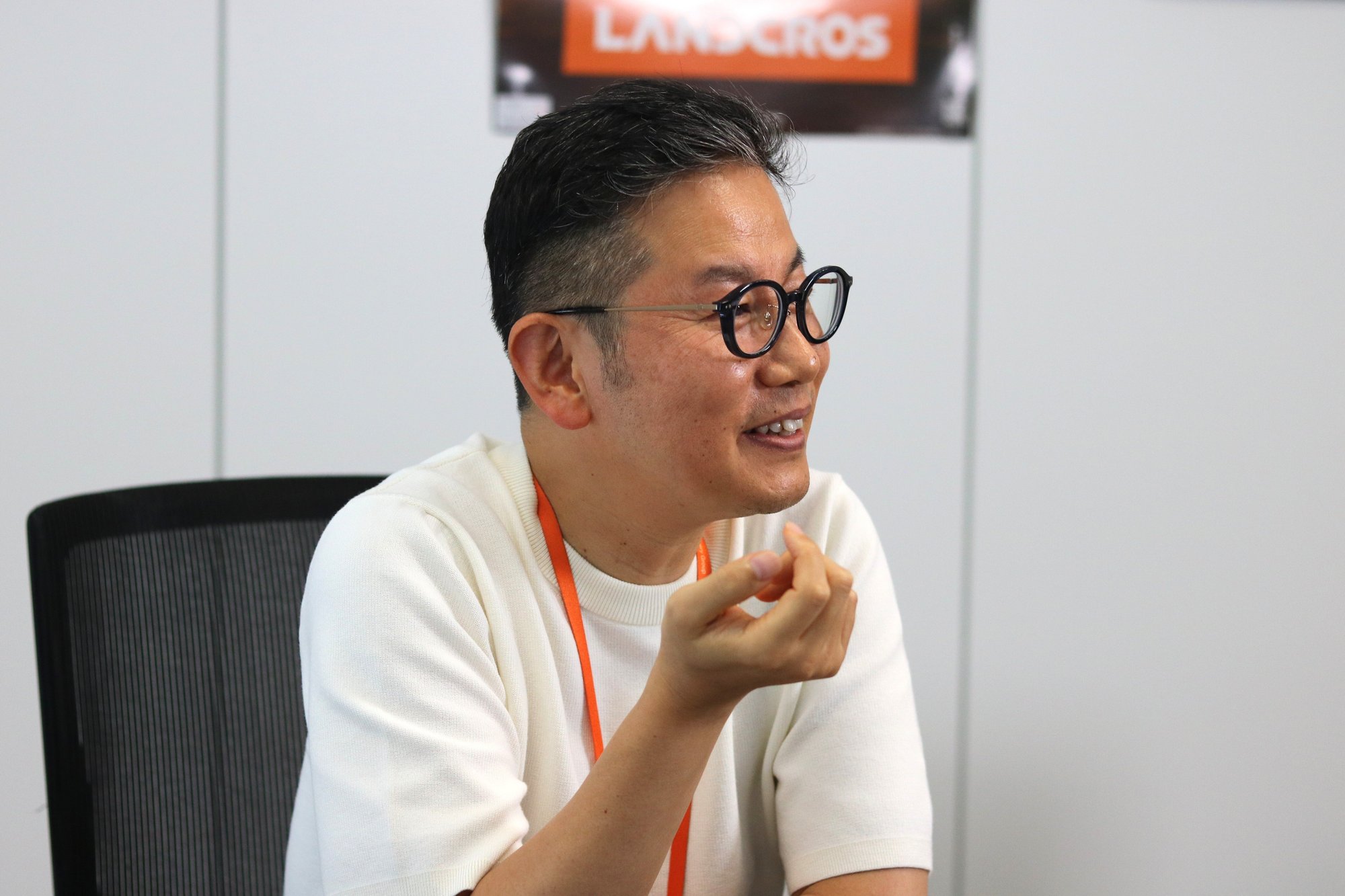 新規事業には「意志」が欠かせないと語る日立建機の森脇氏。背景にLANDCROSのロゴ
