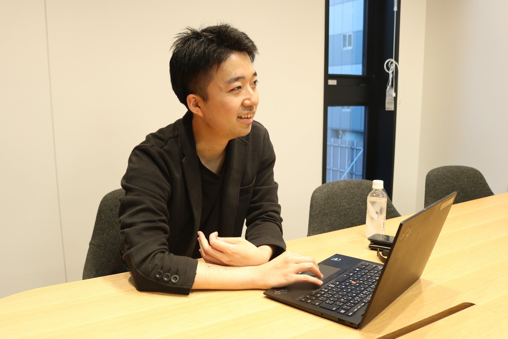 会議室でノートパソコンを前に話すNさん