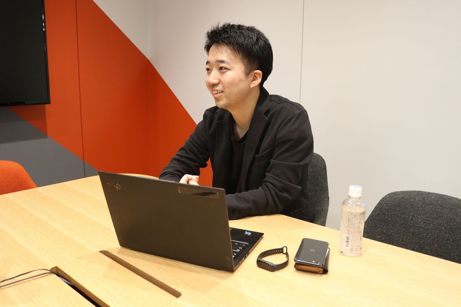 会議室のテーブルでインタビューに答えるNさん
