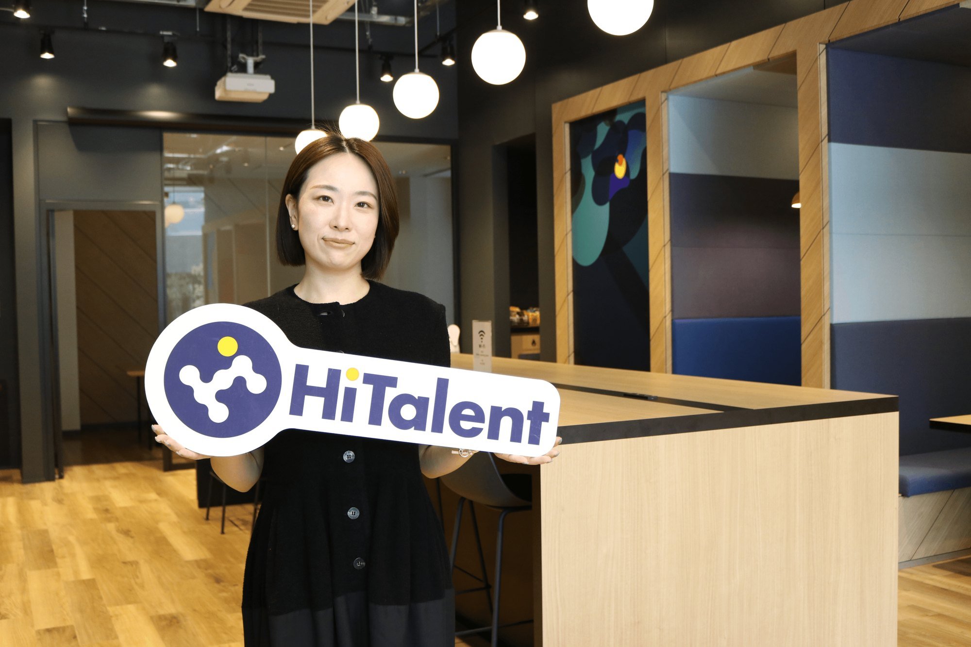HiTalentのロゴボードを持って立つ和田伶美さん