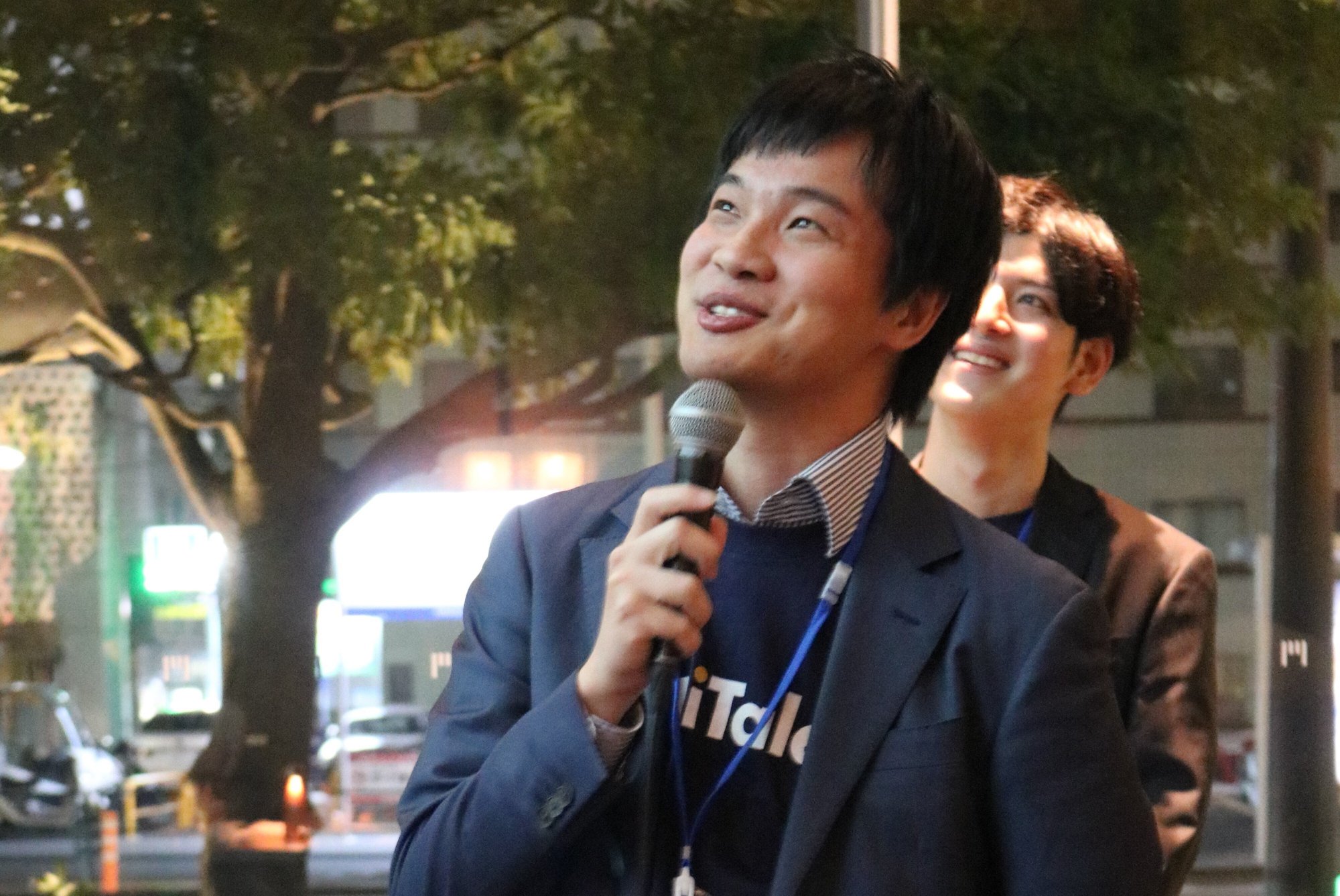 マイクを持ってタレントの皆さまへスピーチする代表取締役の有吉