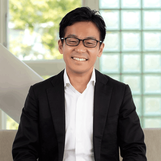 『コンサル・コード』著者の中村健太郎氏。眼鏡をかけ、笑顔で椅子に座ったポートレート