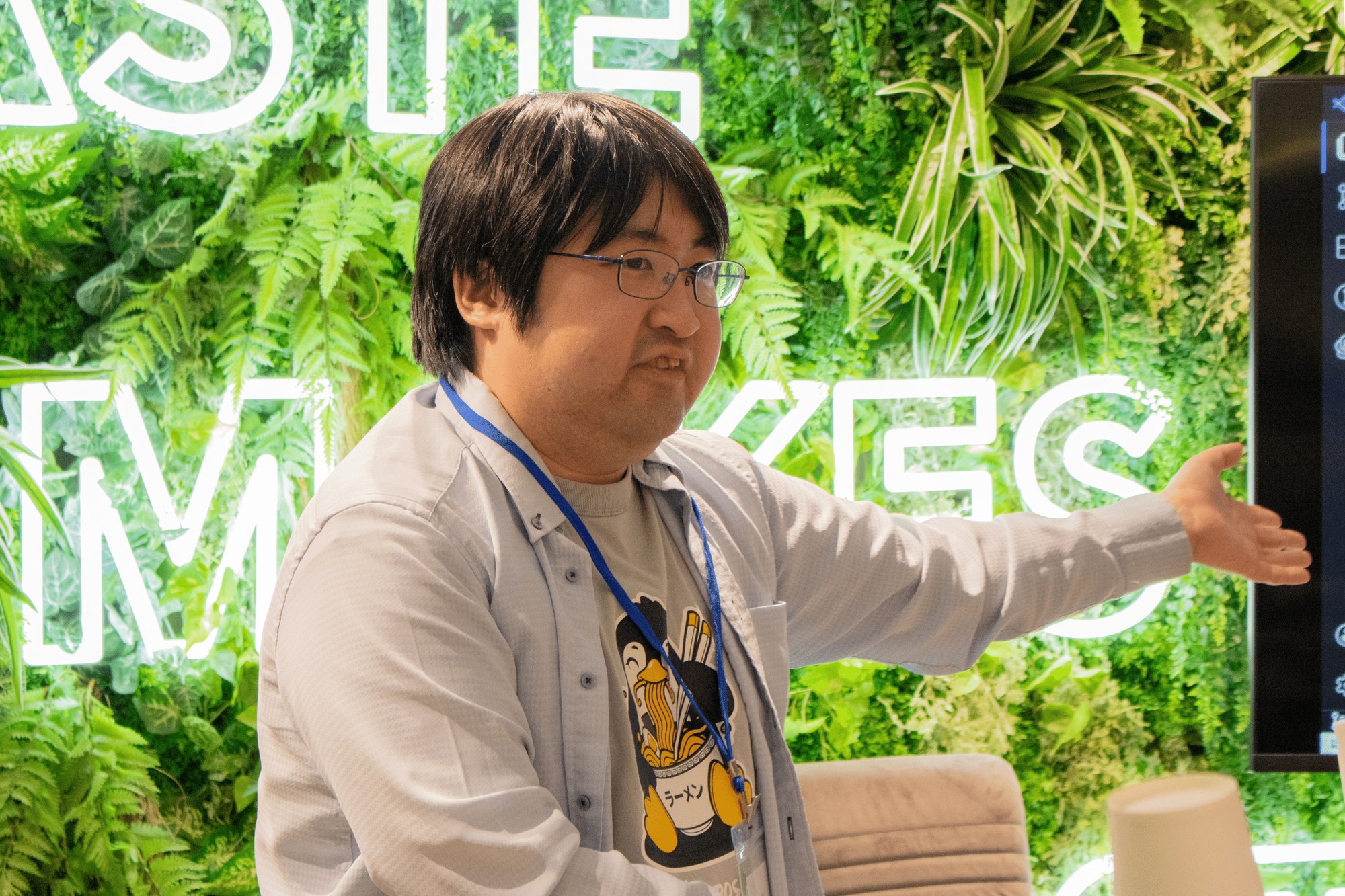 中氏がスクリーンを手で示しながら話している様子。エンジニアの視点から業務自動化の手法を共有した