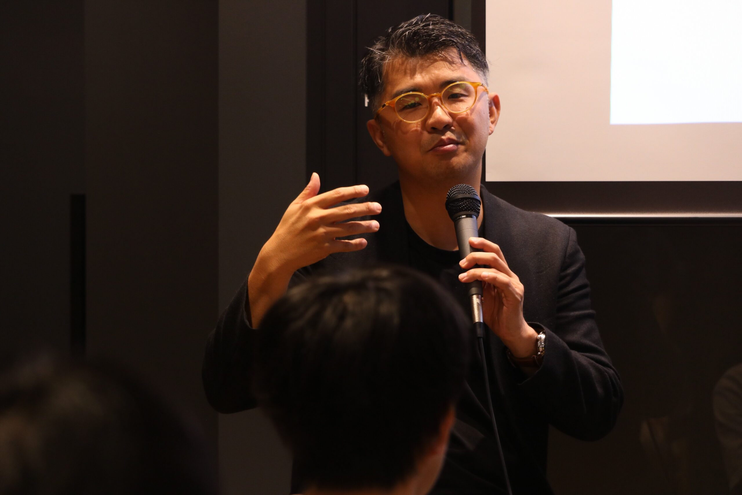 マイクを持ち、手ぶりを交えて講演する佐宗邦威氏