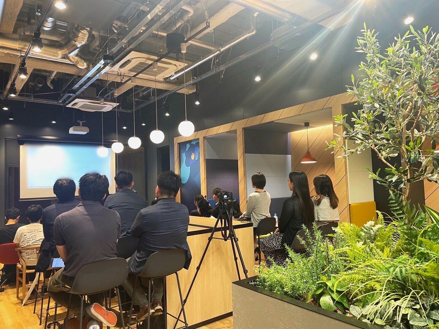 Bizflex六本木の会場。スクリーンに向かって参加者が着席し、後方にカメラが構えられている