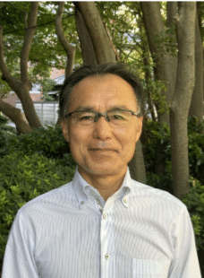 登壇者の水上武彦氏。緑を背にしたポートレート