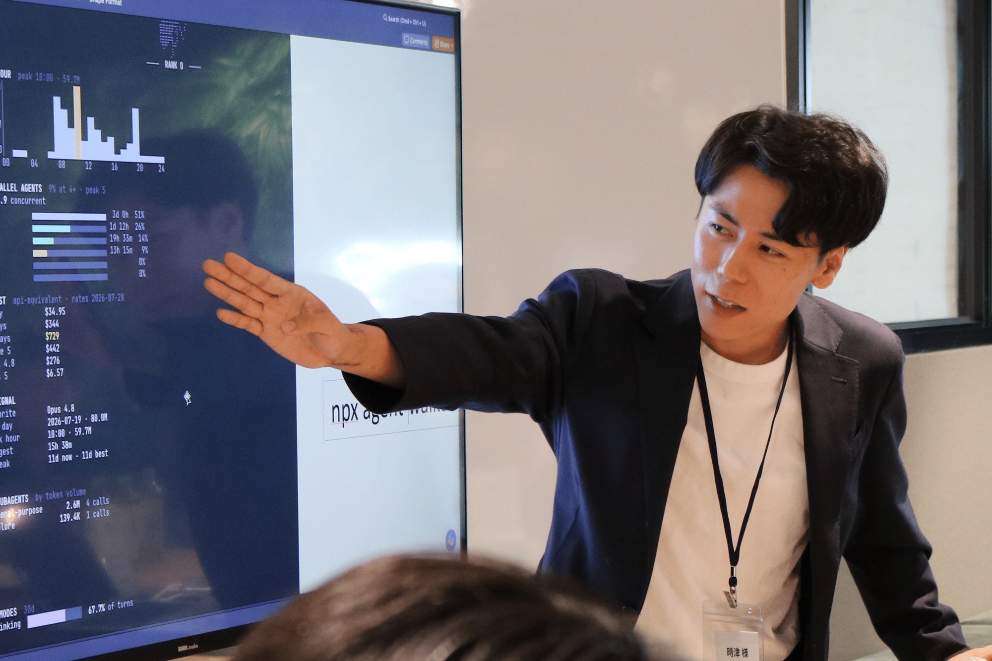 時津遼資氏が、AI利用状況の可視化ツール「Agent Walker」を映したスクリーンを手で指しながら説明している様子