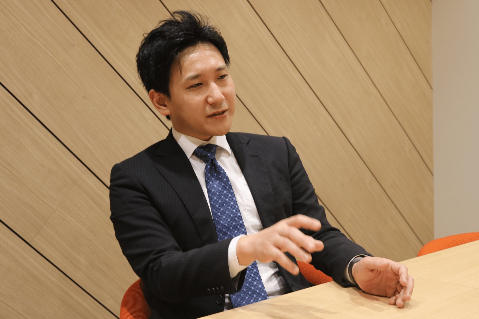 会議室で手ぶりを交えて話す上田雄登さん